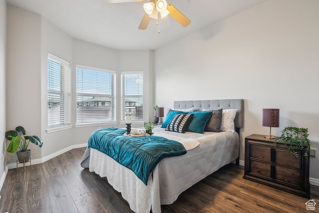 Bedroom featuring wood finished floors, baseboards, and a ceiling fan