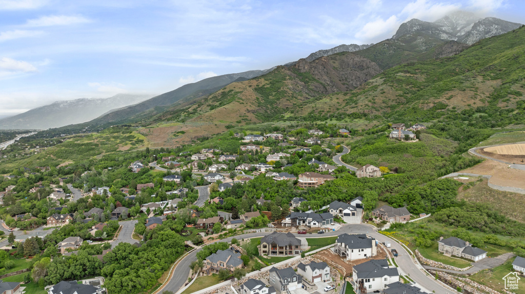Aerial view of property and surrounding area with a mountain backdrop and nearby suburban area