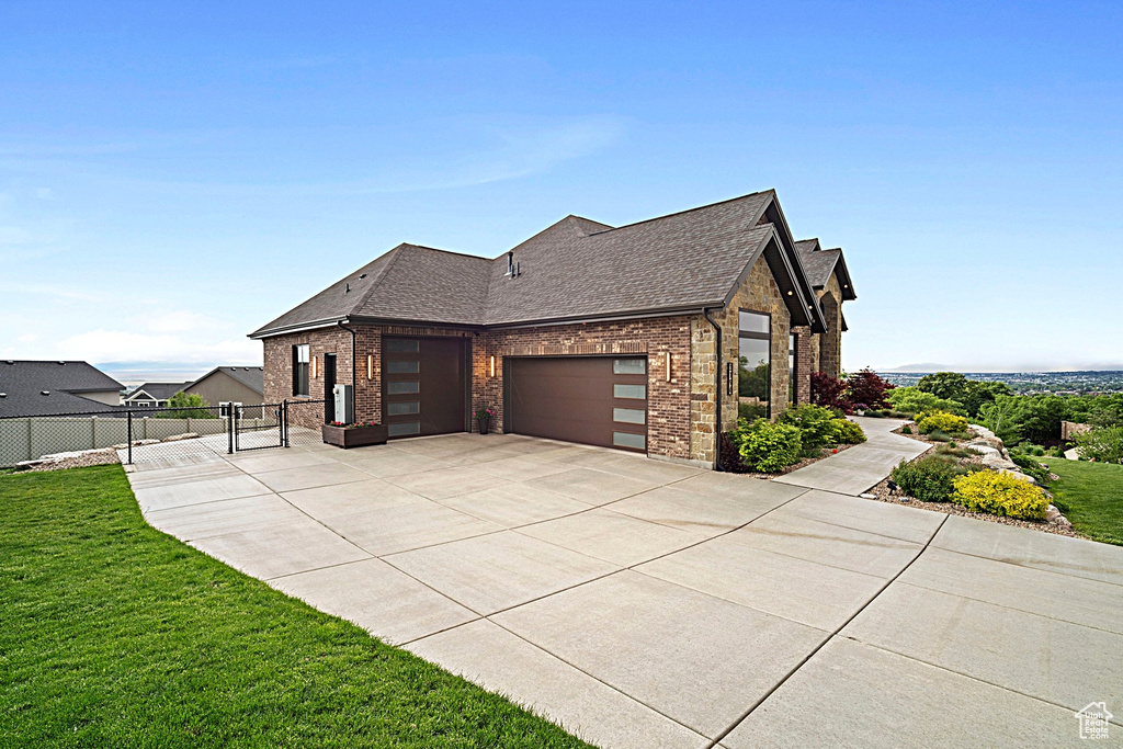 View of side of property featuring brick siding, an attached garage, driveway, and a shingled roof