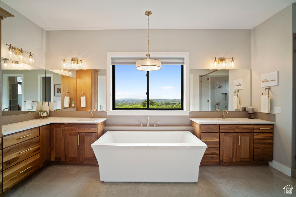 Bathroom with two vanities, a soaking tub, a stall shower, and tile patterned floors