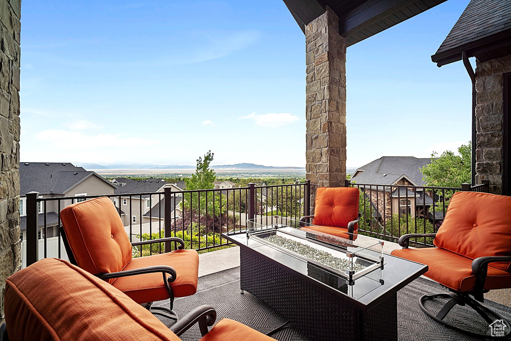 View of patio featuring an outdoor fire pit and a balcony