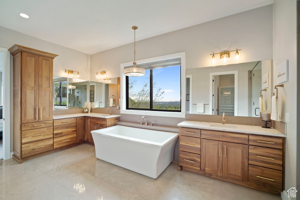 Bathroom with plenty of natural light, a stall shower, a freestanding bath, and two vanities