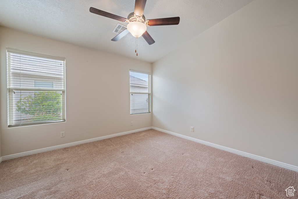 Unfurnished room with light colored carpet, baseboards, and a ceiling fan