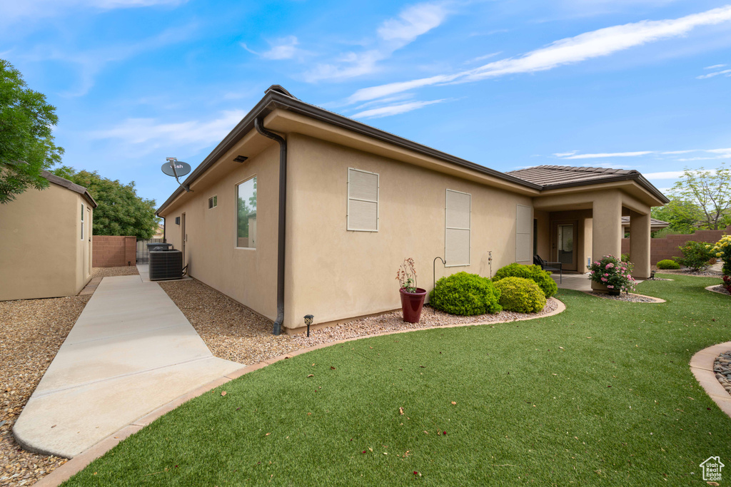 View of side of home featuring central AC unit and stucco siding