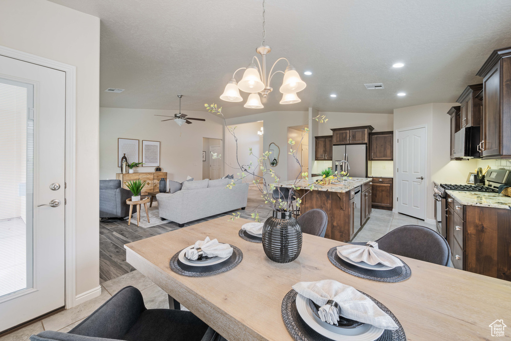 Dining space featuring vaulted ceiling, a chandelier, ceiling fan, recessed lighting, and baseboards