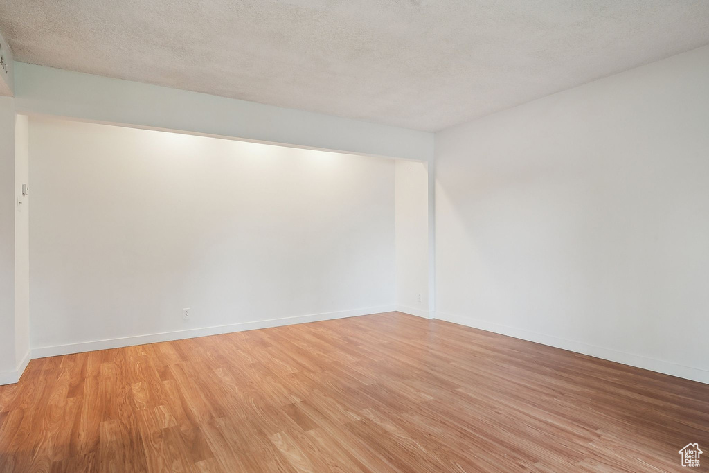 Unfurnished room with light wood-style floors and baseboards
