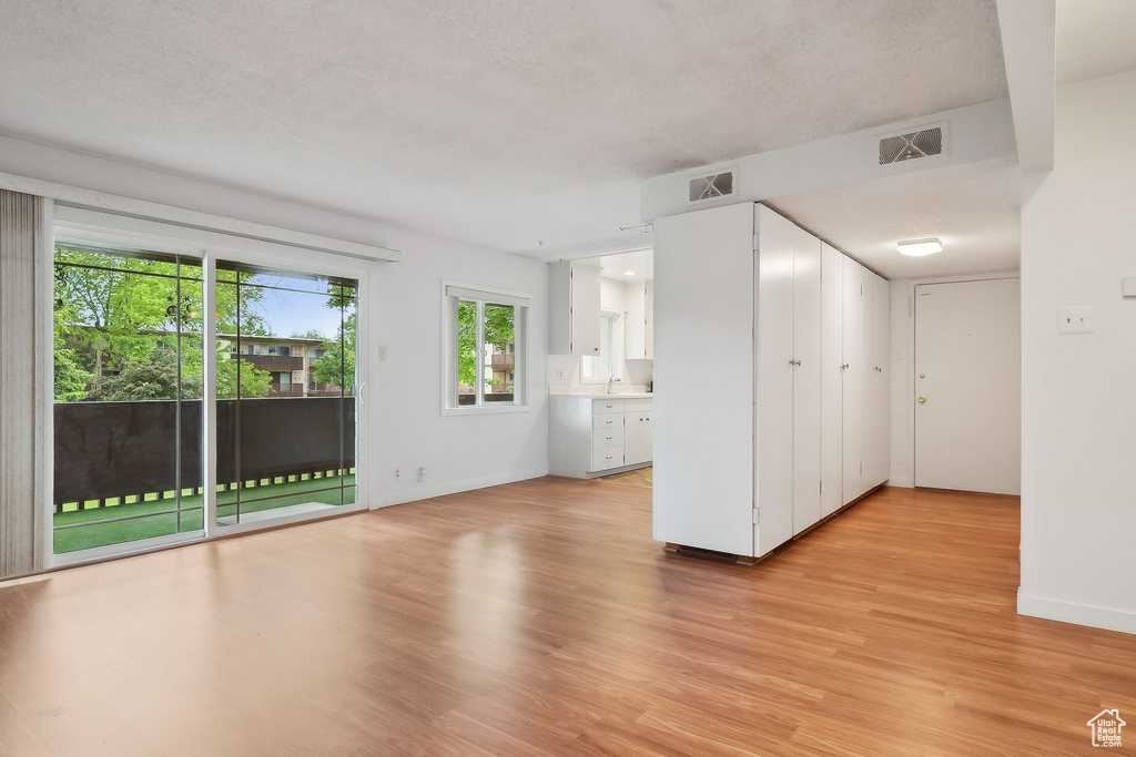 Spare room with light wood finished floors, baseboards, and a sink