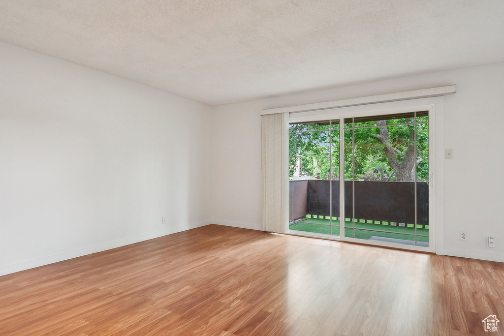 Unfurnished room with wood finished floors and baseboards