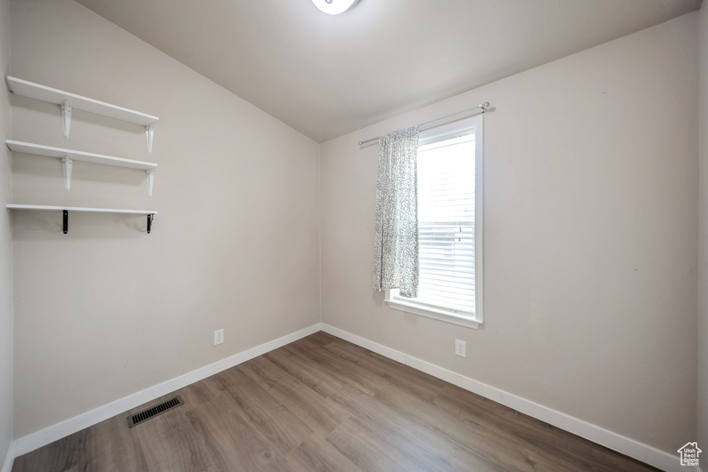 Unfurnished room with lofted ceiling and wood finished floors
