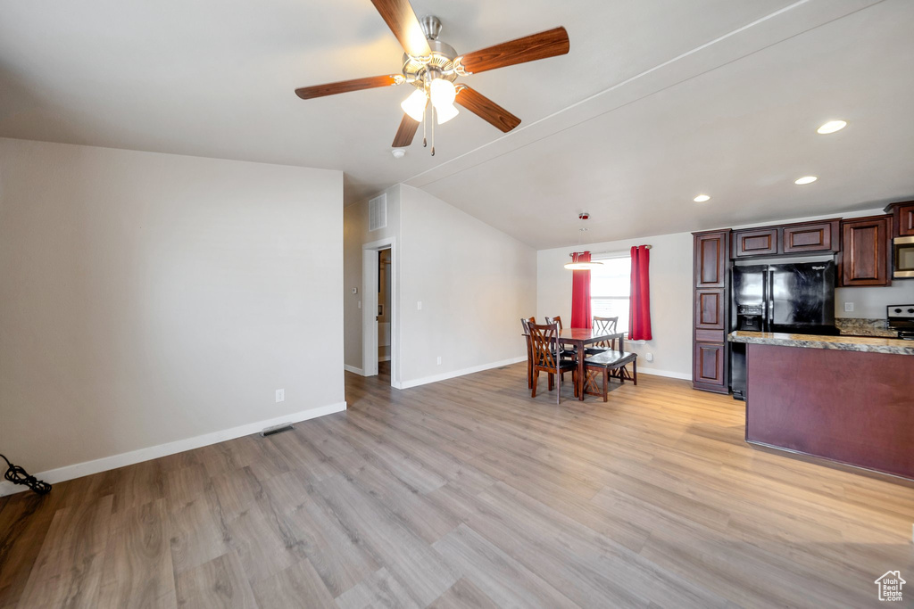 Kitchen featuring vaulted ceiling, ceiling fan, appliances with stainless steel finishes, light wood finished floors, and recessed lighting
