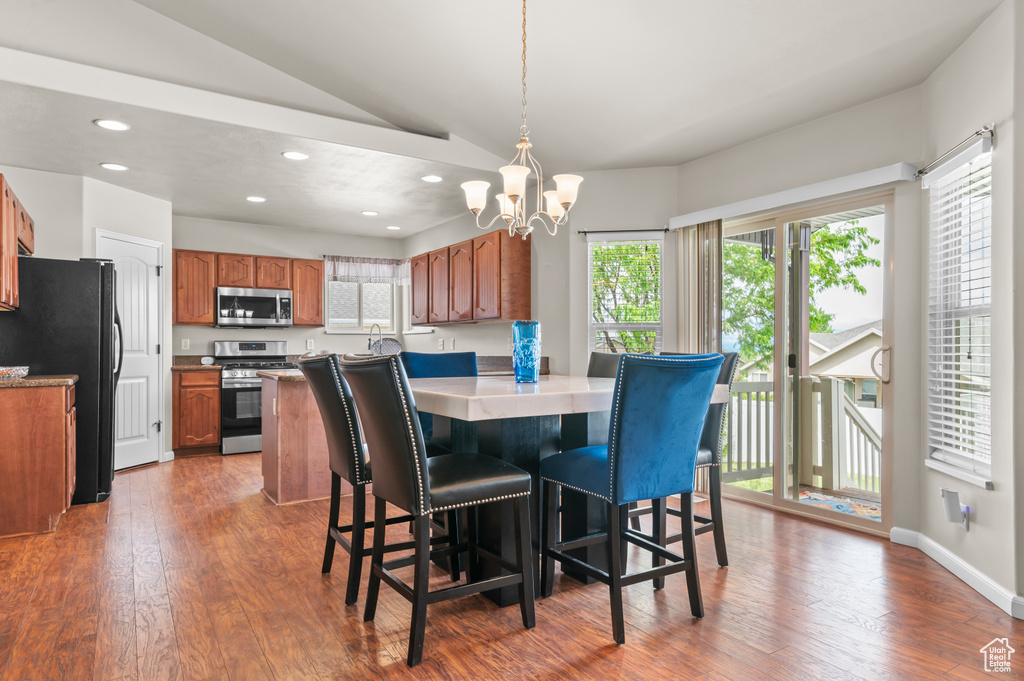 Dining space featuring plenty of natural light, a chandelier, recessed lighting, dark wood-style flooring, and lofted ceiling