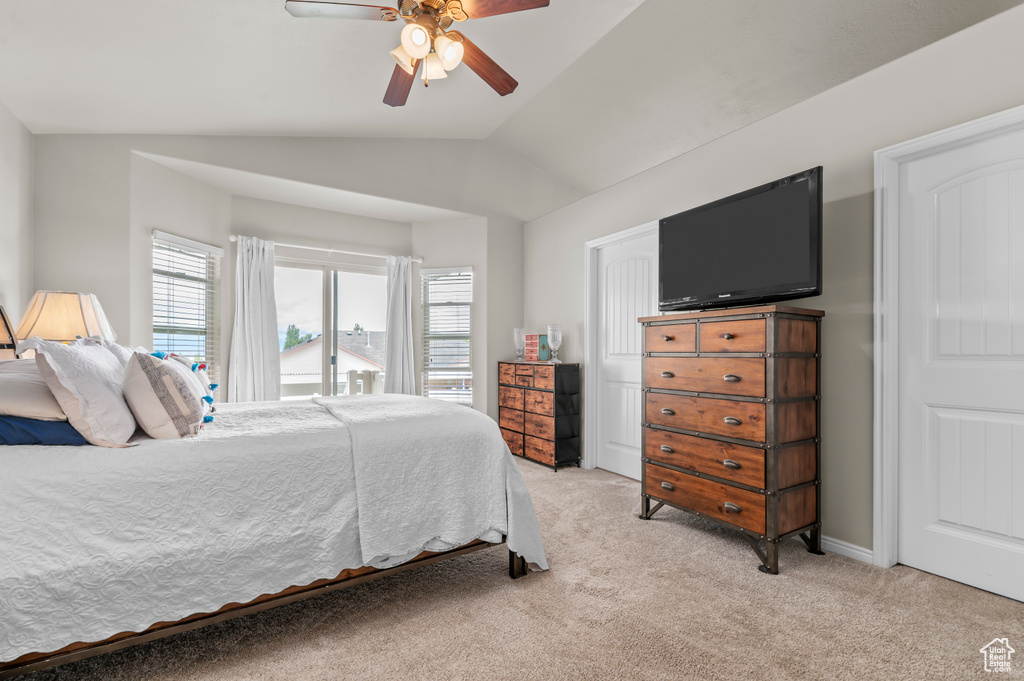 Bedroom with light colored carpet, lofted ceiling, and a ceiling fan