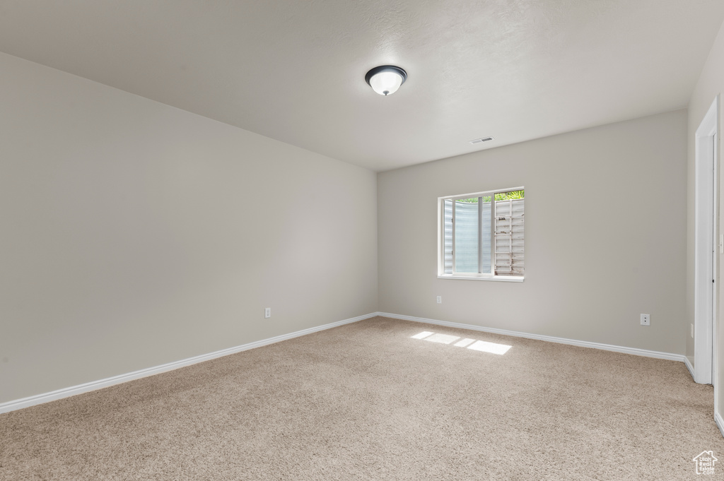Unfurnished room with light colored carpet and baseboards