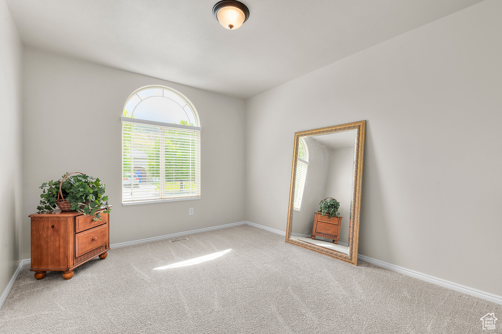 Empty room with light carpet and baseboards