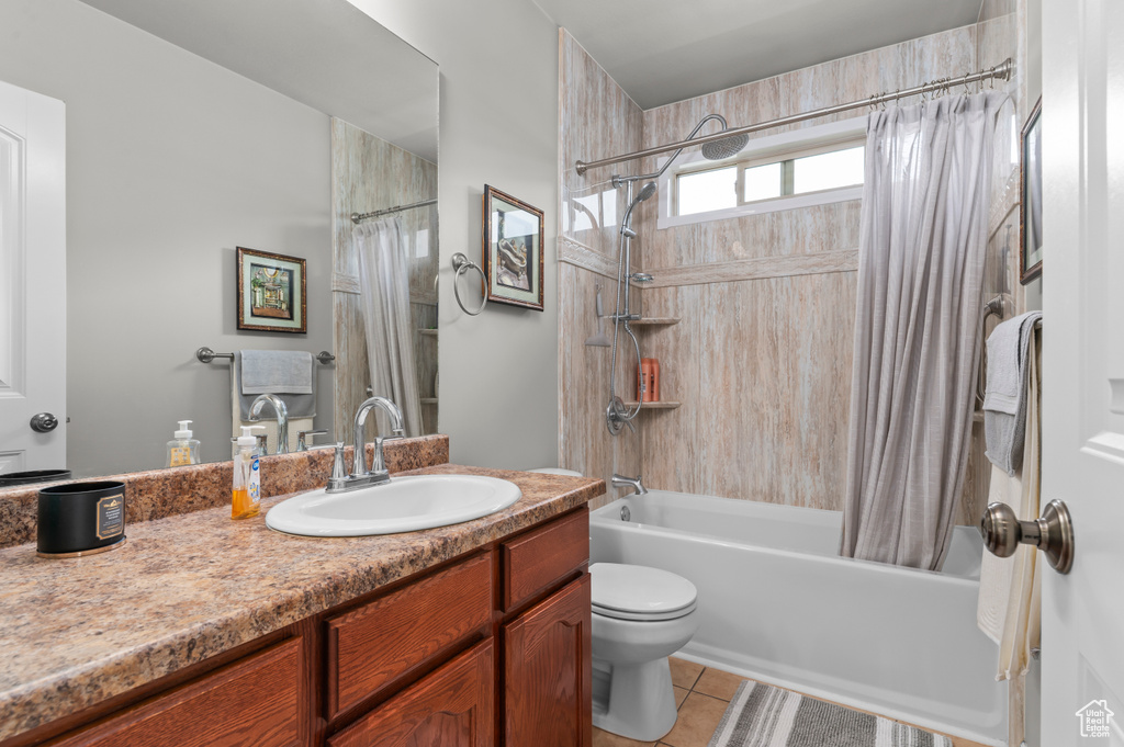 Bathroom with shower / bathtub combination with curtain, tile patterned flooring, vanity, and toilet