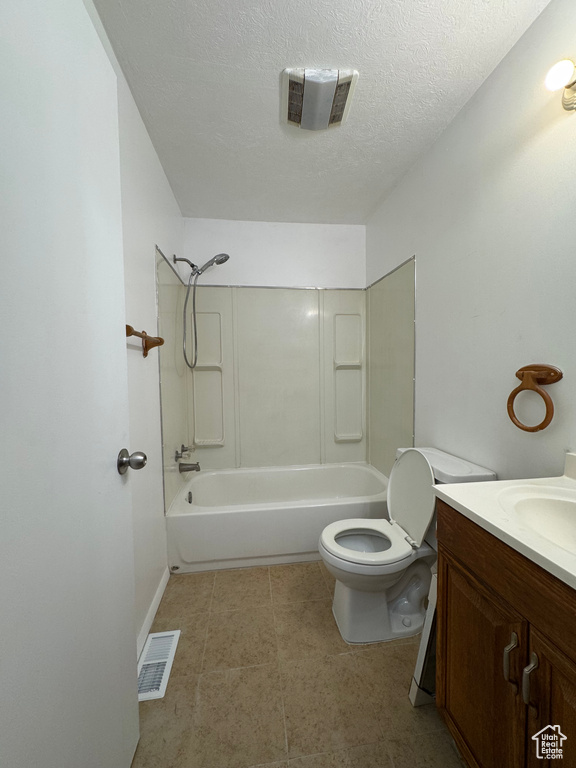 Bathroom featuring shower / washtub combination, toilet, vanity, and a textured ceiling