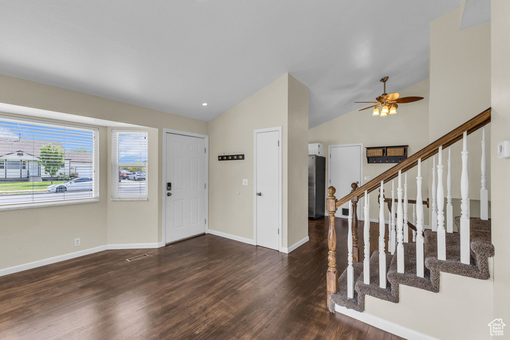 Entryway featuring wood finished floors, ceiling fan, baseboards, high vaulted ceiling, and stairs