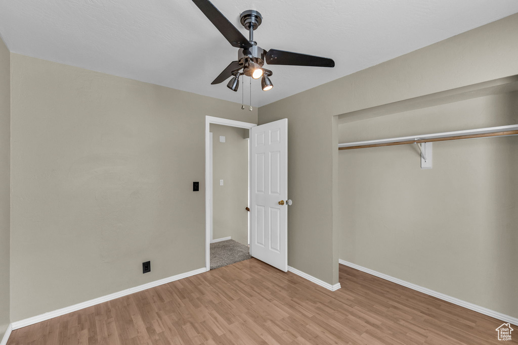 Unfurnished bedroom with wood finished floors, baseboards, a closet, and ceiling fan