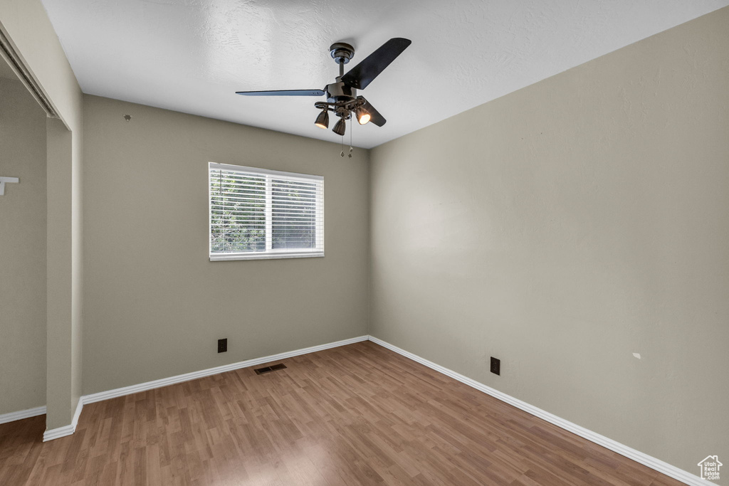 Spare room featuring ceiling fan, wood finished floors, and baseboards