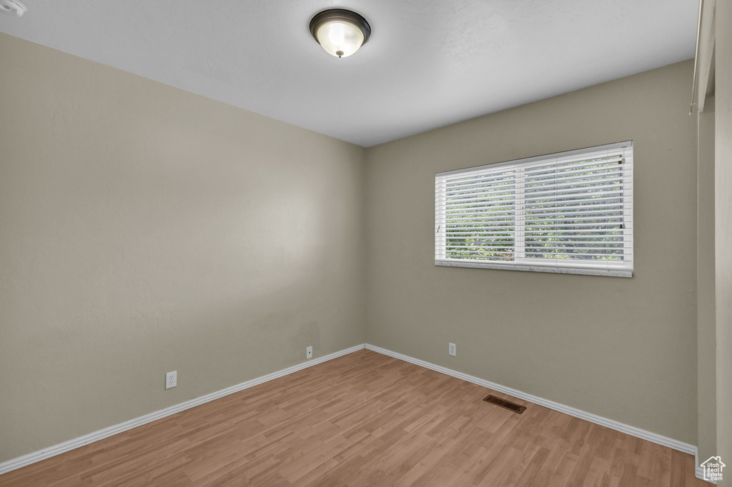 Unfurnished room with light wood finished floors and baseboards