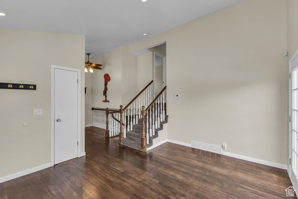 Empty room with wood finished floors, a ceiling fan, stairs, baseboards, and recessed lighting