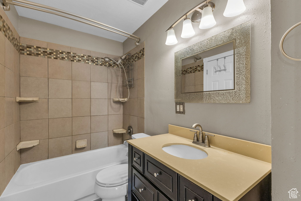 Bathroom featuring toilet, vanity, and washtub / shower combination