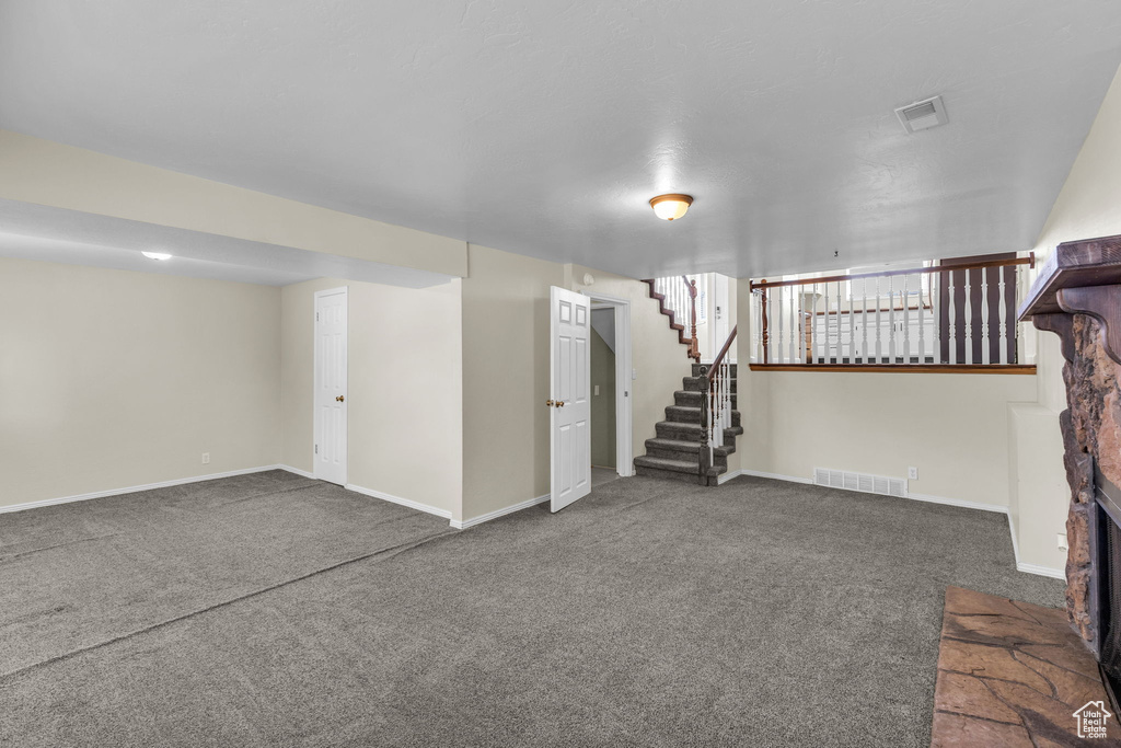 Finished below grade area featuring carpet flooring, stairs, and baseboards
