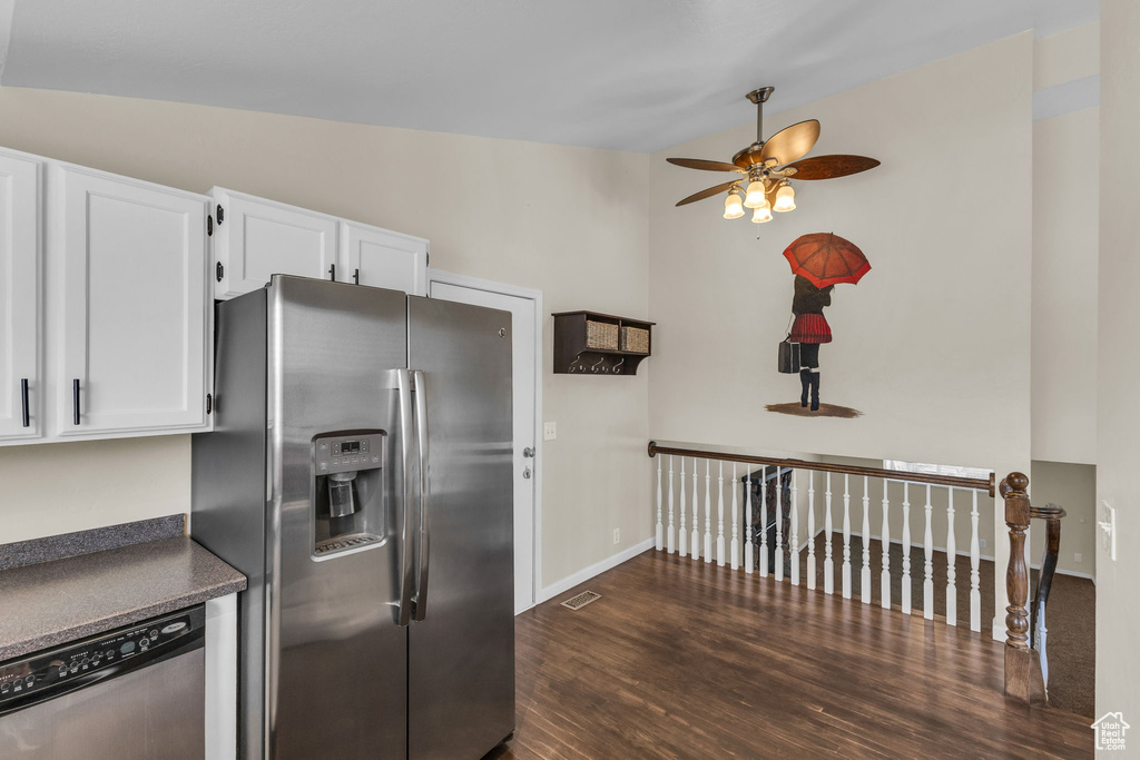 Kitchen with stainless steel appliances, ceiling fan, dark wood finished floors, dark countertops, and white cabinets