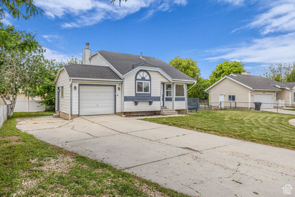 View of front of property with a chimney, a garage, concrete driveway, and roof with shingles