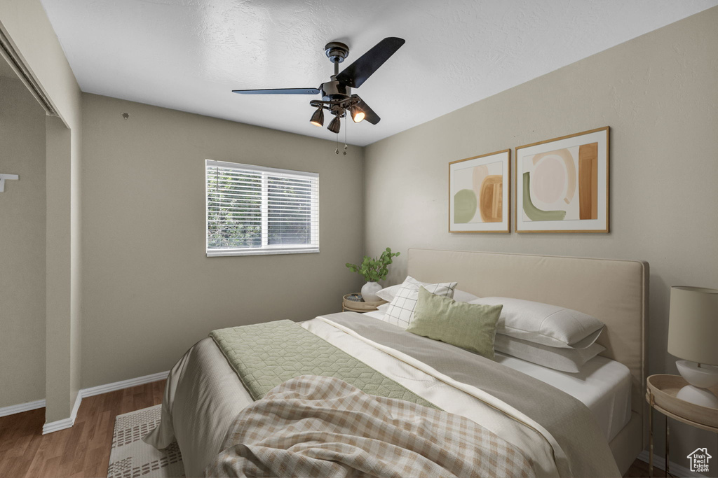 Bedroom featuring wood finished floors, baseboards, ceiling fan, and a closet