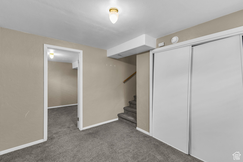 Finished below grade area featuring carpet, baseboards, and stairs