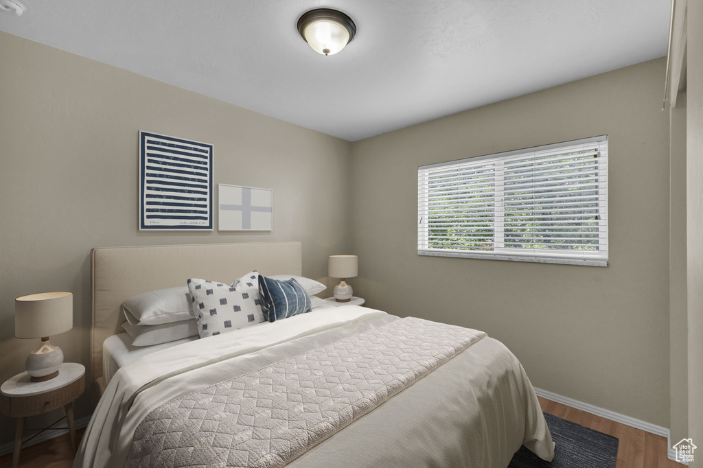 Bedroom with wood finished floors and baseboards