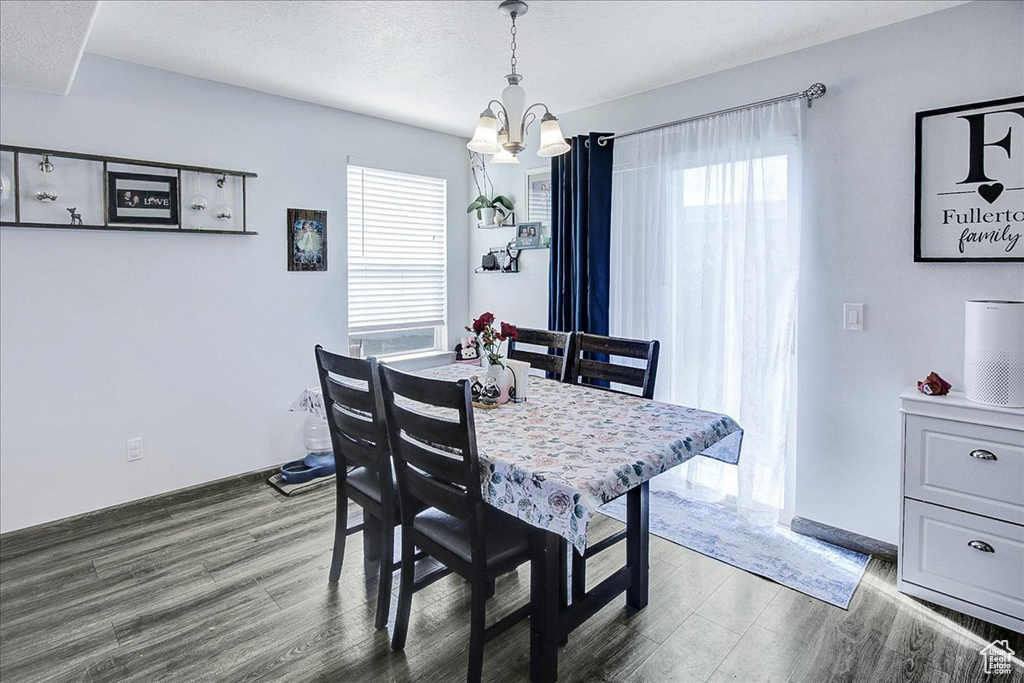 Dining room featuring a chandelier, wood finished floors, and plenty of natural light