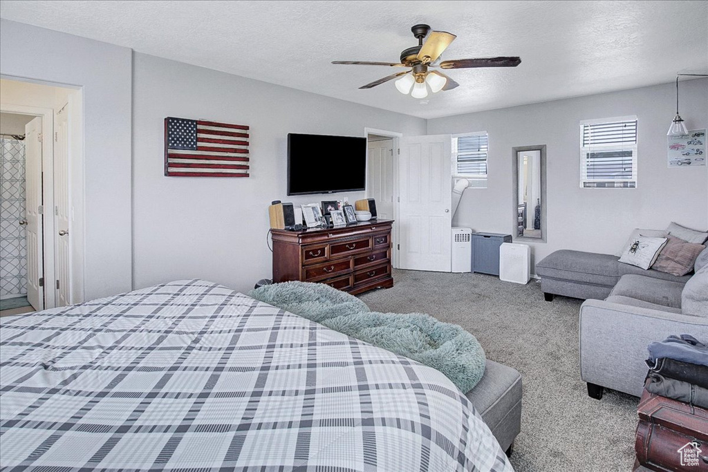Carpeted bedroom with a textured ceiling and a ceiling fan