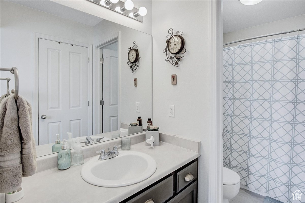Full bathroom with vanity, toilet, and a shower with curtain