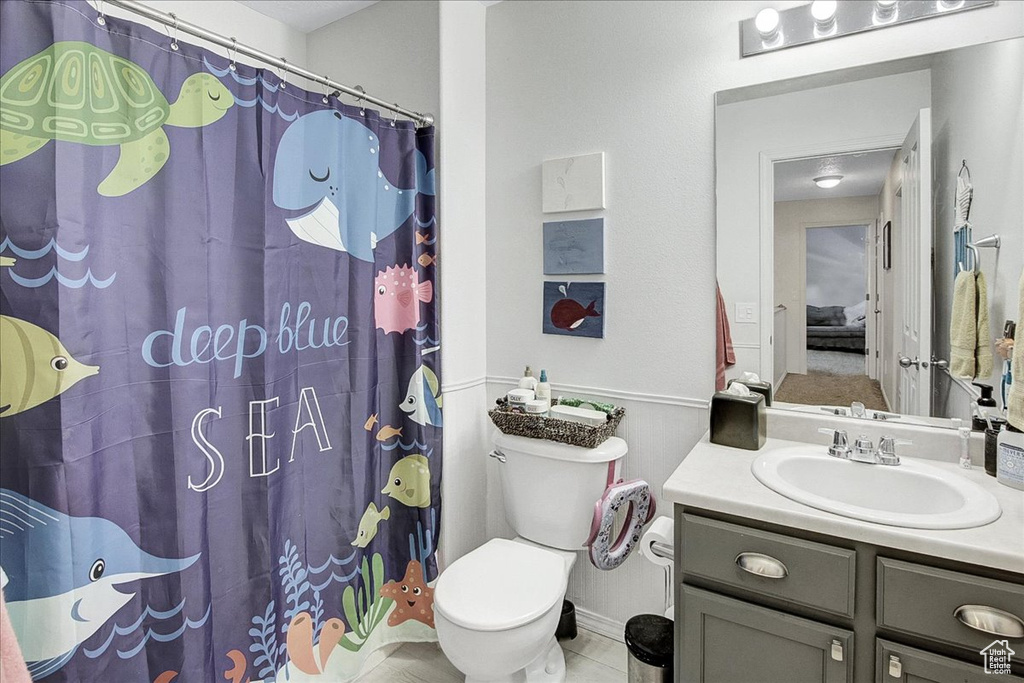 Full bath with vanity, toilet, curtained shower, and tile patterned flooring