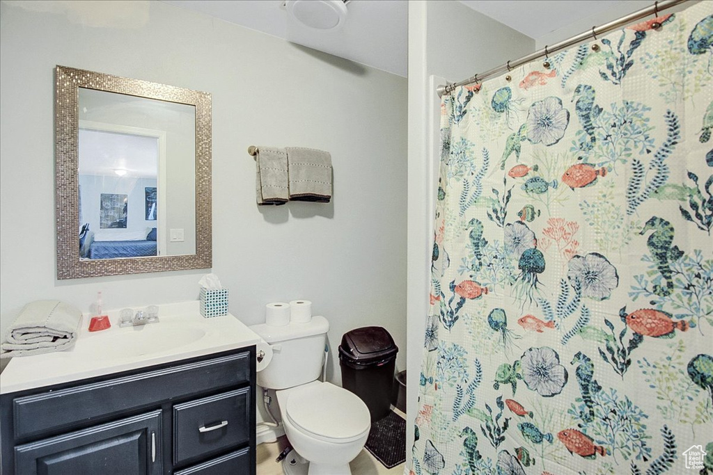 Bathroom with toilet, vanity, and a shower with shower curtain