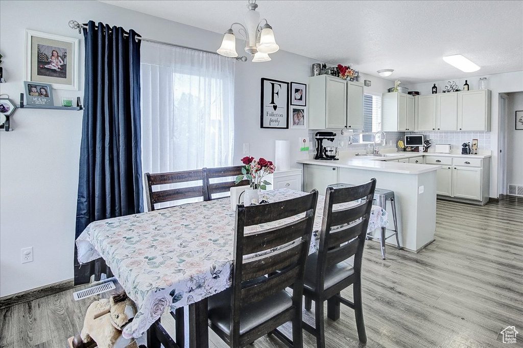 Dining area featuring a chandelier and light wood-style floors