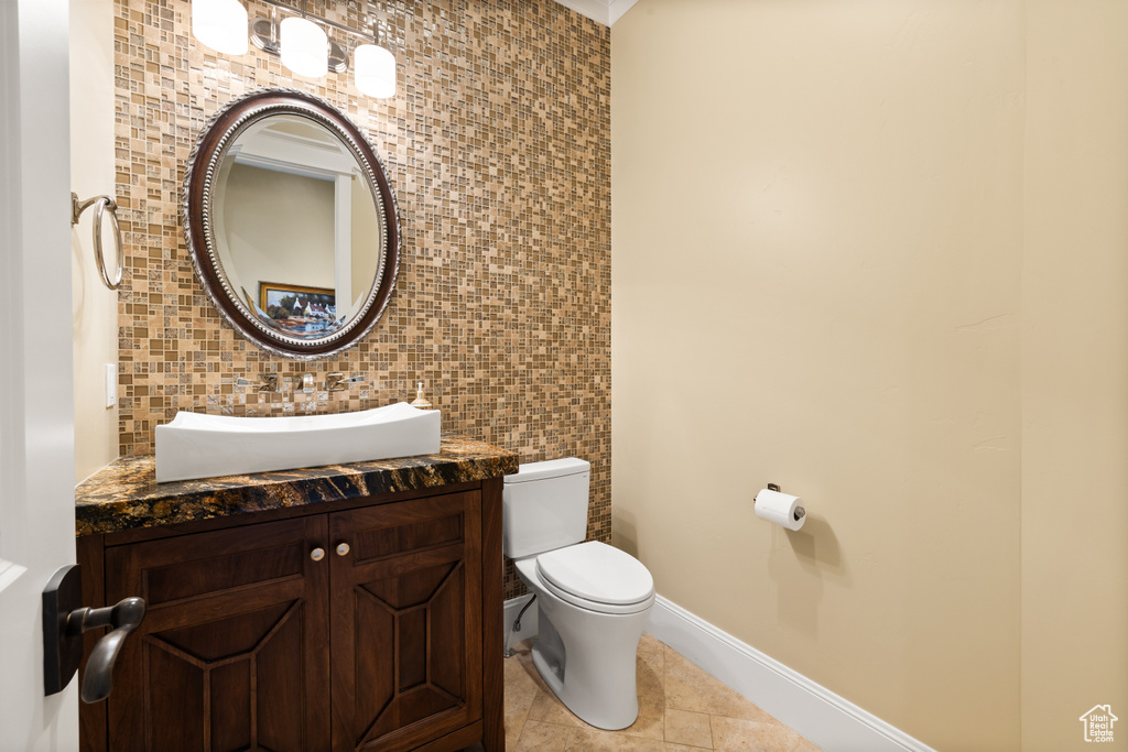 Half bathroom featuring tile walls, toilet, tile patterned floors, and vanity