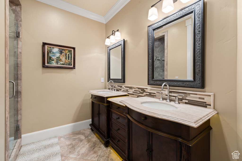 Full bath with tasteful backsplash, ornamental molding, vanity, an enclosed shower, and baseboards