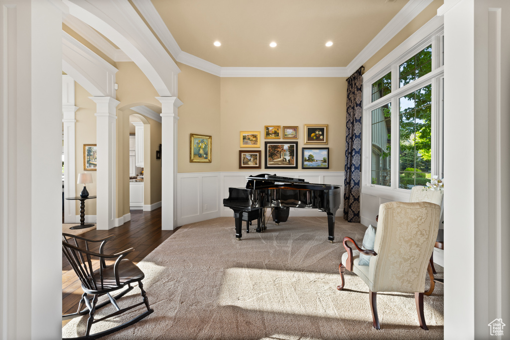 Home office with decorative columns, arched walkways, ornamental molding, wainscoting, and wood finished floors