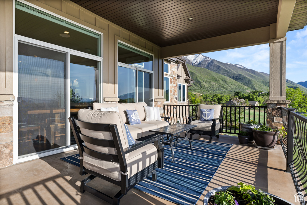 Wooden terrace featuring a mountain view and an outdoor living space