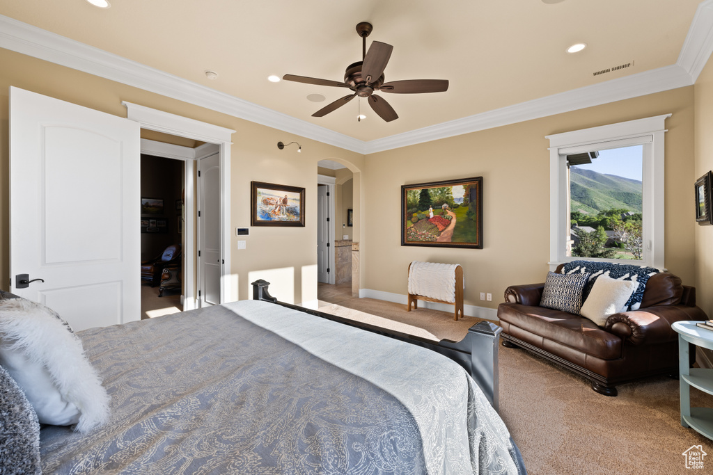 Carpeted bedroom featuring arched walkways, ornamental molding, baseboards, recessed lighting, and ceiling fan