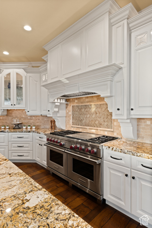 Kitchen with double oven range, white cabinets, and recessed lighting