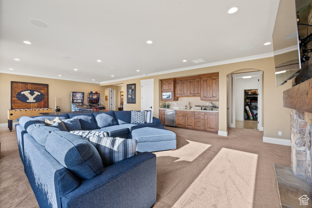 Living area featuring light colored carpet, recessed lighting, baseboards, arched walkways, and wet bar