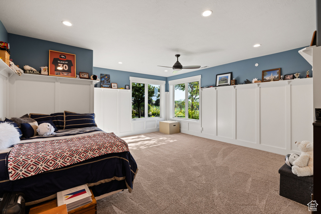 Bedroom with a decorative wall, recessed lighting, carpet floors, wainscoting, and ceiling fan