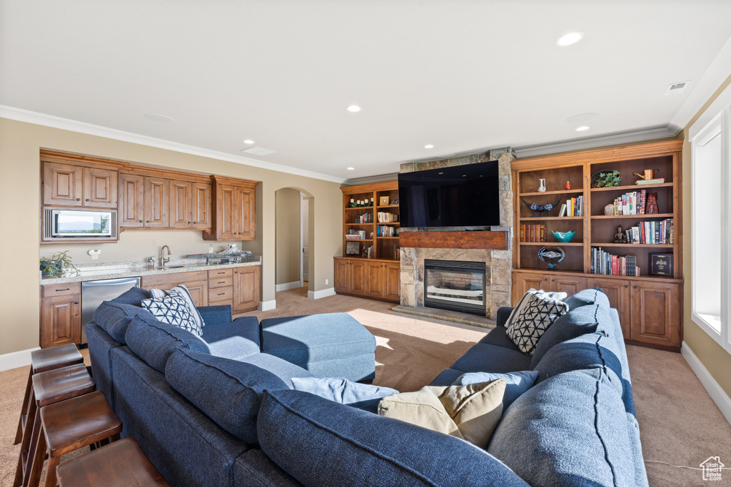 Living room featuring light colored carpet, baseboards, arched walkways, crown molding, and recessed lighting