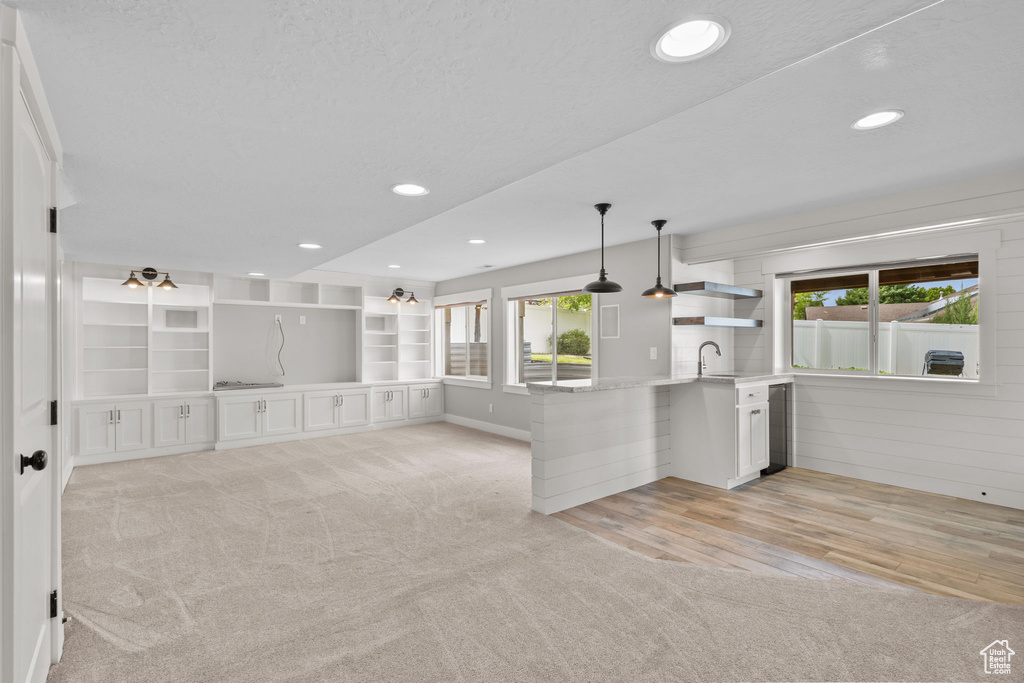 Kitchen featuring healthy amount of natural light, light carpet, open shelves, and recessed lighting