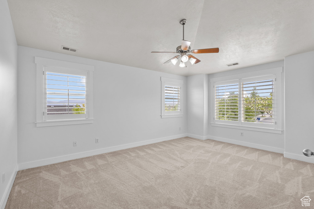 Spare room featuring a ceiling fan, baseboards, carpet flooring, and a textured ceiling