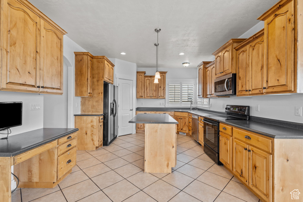 Kitchen with appliances with stainless steel finishes, a sink, dark countertops, a center island, and light tile patterned floors